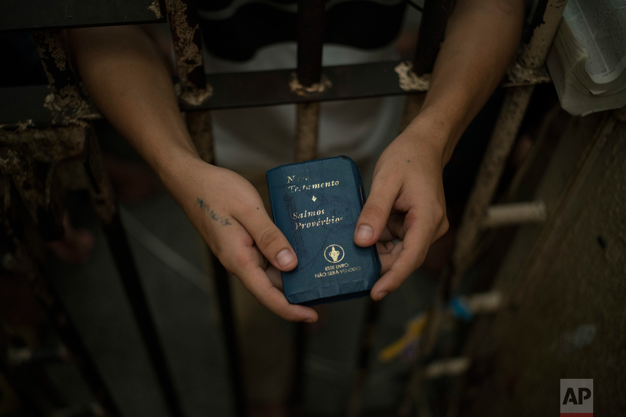 In this Feb. 6, 2017 photo, a detainee holds a Bible inside an overcrowded cell at a police station near Manaus, Brazil. A recent study by think-tank Fundacao Getulio Vargas estimates that 40 percent of Brazilian prisoners have not been convicted. (AP Photo/Felipe Dana)