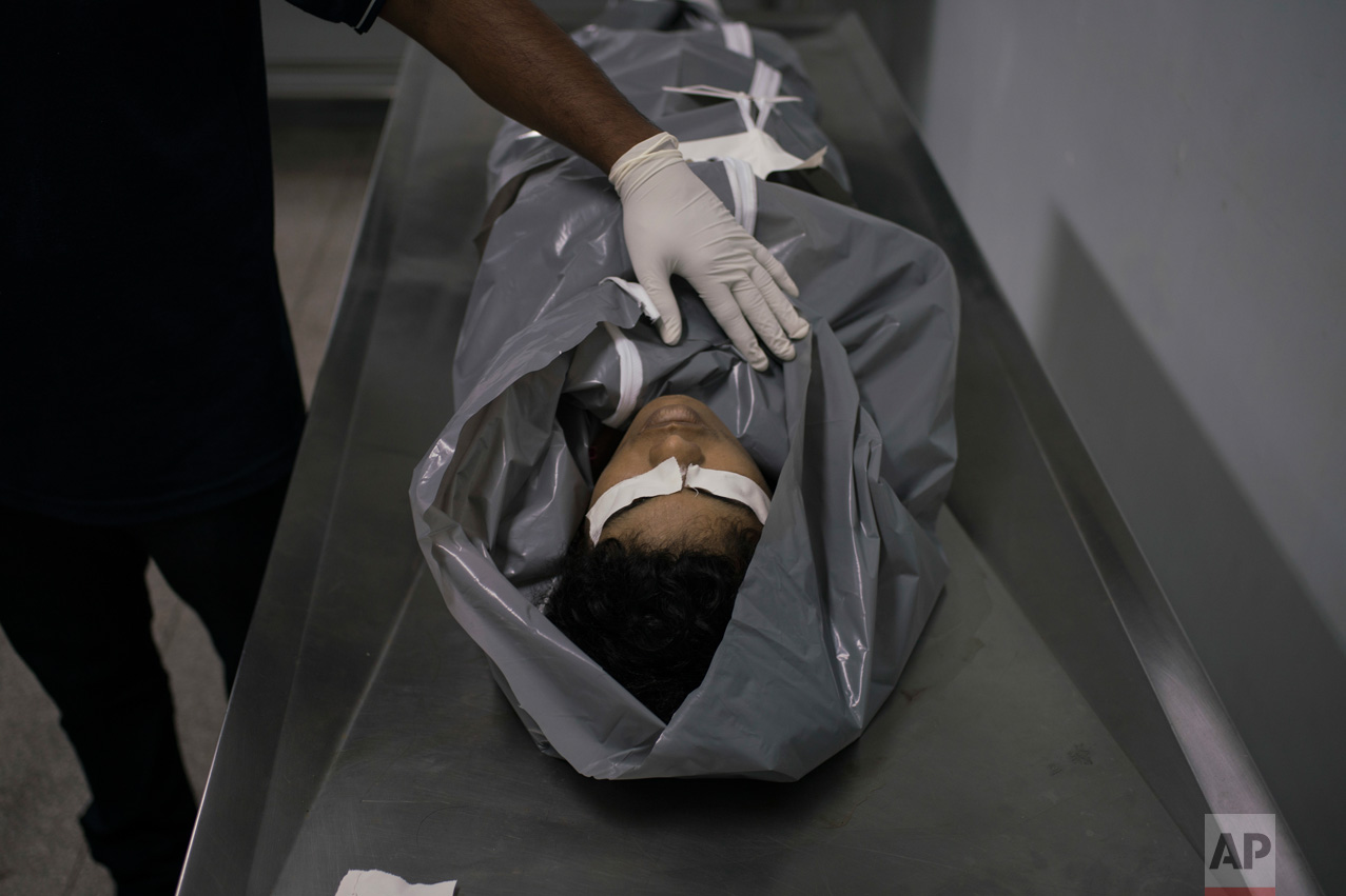 In this Feb. 4, 2017 photo, a morgue worker prepares the body of a homicide victim at a hospital in Manaus, Brazil. According to Claudio Lamachia, head of Brazil's bar association, Brazil's prisons are universities of crime, and from the inside, leaders give orders to commit crimes on the outside, including murder. (AP Photo/Felipe Dana)