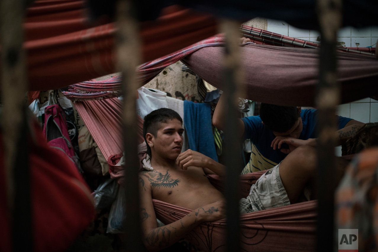 In this Feb. 6, 2017 photo, detainees rest in hammocks inside an overcrowded cell at a police station near Manaus, Brazil. All 24 inmates at the station said they were linked to the Family of the North gang, but guards said that could be just a defensive move after a slaughter at the city's main jail, Complexo Penitenciario Anisio Jobim. (AP Photo/Felipe Dana)