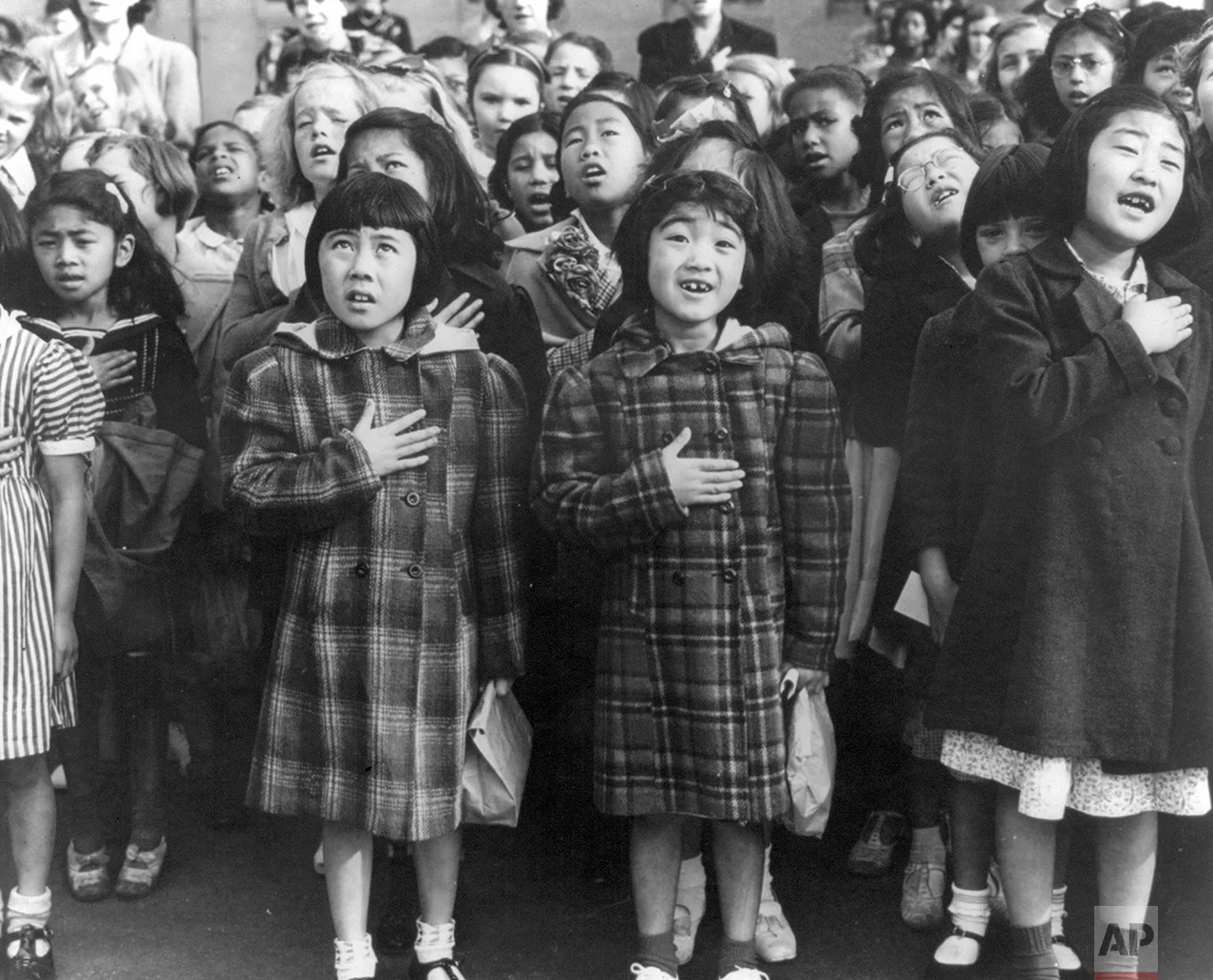 In this April 1942 photo made available by the Library of Congress, children at the Weill public school in San Francisco recite the Pledge of Allegiance. Some of them are evacuees of Japanese ancestry who will be housed in War Relocation Authority centers for the duration of the war. Roughly 120,000 Japanese immigrants and Japanese-Americans were sent to camps that dotted the West because the government claimed they might plot against the U.S. (Dorothea Lange/U.S. War Relocation Authority via AP)