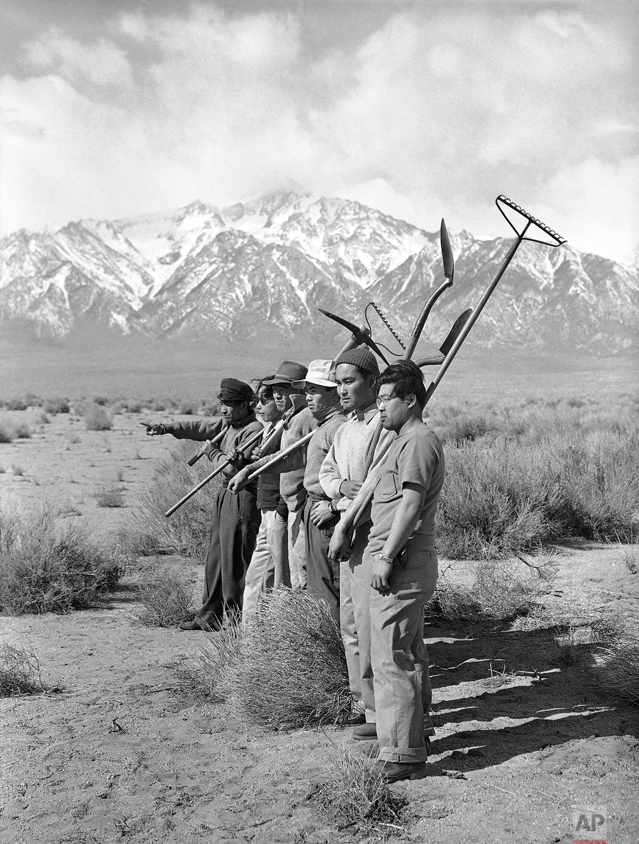 Japanese are making themselves comfortable in their barrack-like surroundings. They are helping the construction of building and planning farms for the future. A group surveys the lands in hope of starting a garden March 27, 1942. (AP Photo)
