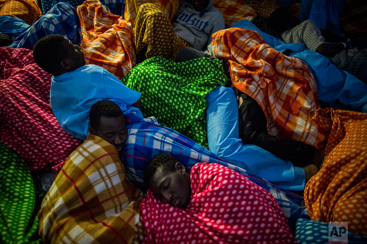 Refugees and migrants rest aboard the Golfo Azurro, the Spanish NGO Proactiva Open Arms rescue ship after being rescued off the Libyan coast, early in the morning on Thursday Feb. 23, 2017. (AP Photo/Santi Palacios)