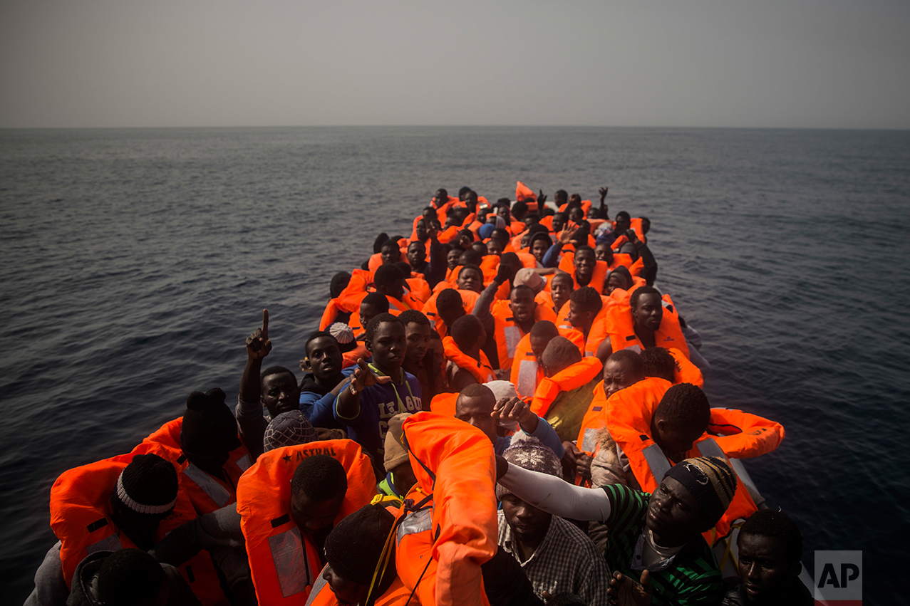 African refugees and migrants, mostly from Sudan and Senegal, wait aboard a rubber boat out of control to be assisted by an NGO, 25 miles north of Sabratha, off the Libyan coast, early in the morning on Thursday, Feb. 23, 2017. (AP Photo/Santi Palacios)