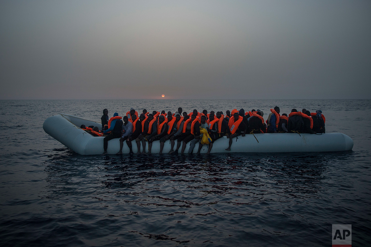 African refugees and migrants, mostly from Sudan and Senegal, wait aboard a rubber boat out of control to be assisted by an NGO, 25 miles north of Sabratha, off the Libyan coast, early in the morning on Thursday, Feb. 23, 2017. (AP Photo/Santi Palacios)