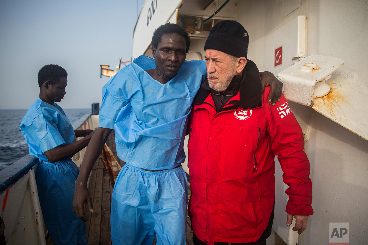 A member of the Spanish NGO Proactiva Open Arms crew helps an injured migrant aboard Golfo Azurro rescue ship, after a rescue operation 25 milles north of Sabratha, off the Libyan coast, early in the morning on Thursday Feb. 23, 2017. (AP Photo/Santi Palacios)