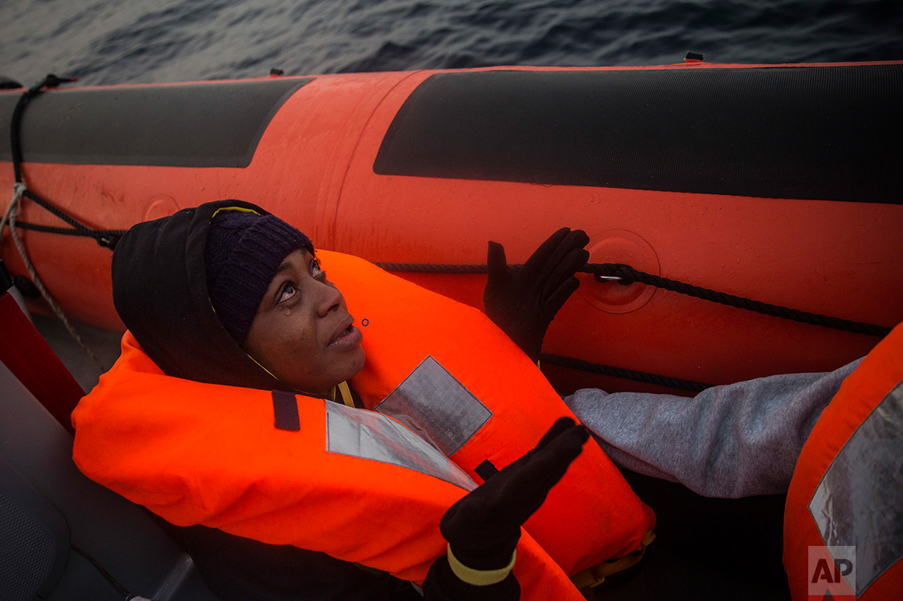 A Nigerian woman prays as she cries aboard a rescue boat, after being rescued by members of the Spanish NGO Proactiva Open Arms, when she was traveling with 98 other African refugees and migrants, mostly from Sudan and Senegal, aboard a rubber boat out of control at 25 miles north of Sabratha, off the Libyan coast, early in the morning on Thursday Feb. 23, 2017. (AP Photo/Santi Palacios)