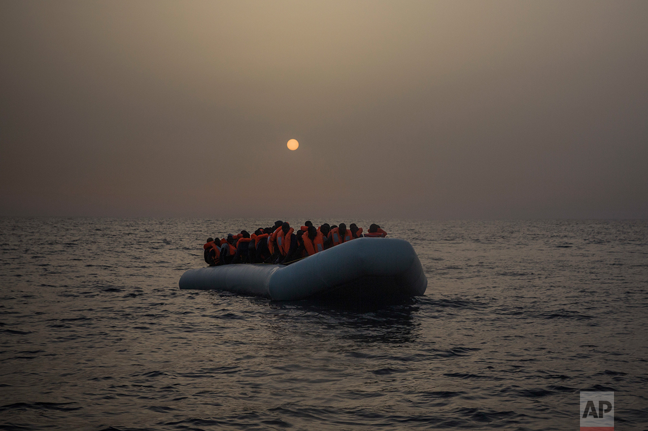 African refugees and migrants, mostly from Sudan and Senegal, wait aboard a rubber boat out of control to be assisted by an NGO, 25 miles north of Sabratha, off the Libyan coast, early in the morning on Thursday, Feb. 23, 2017. (AP Photo/Santi Palacios)