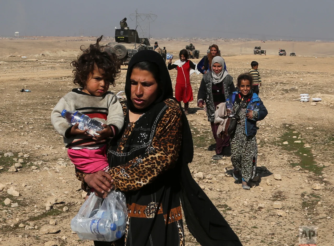 Displaced Iraqis flee their homes due to fighting between Iraqi special forces and Islamic State militants, on the western side of Mosul, Iraq, Thursday, Feb. 2017. The Iraqi security forces advance comes as part of a major assault that started five days earlier to drive Islamic State militants from the western half of Mosul, Iraq's second-largest city. (AP Photo/ Khalid Mohammed)