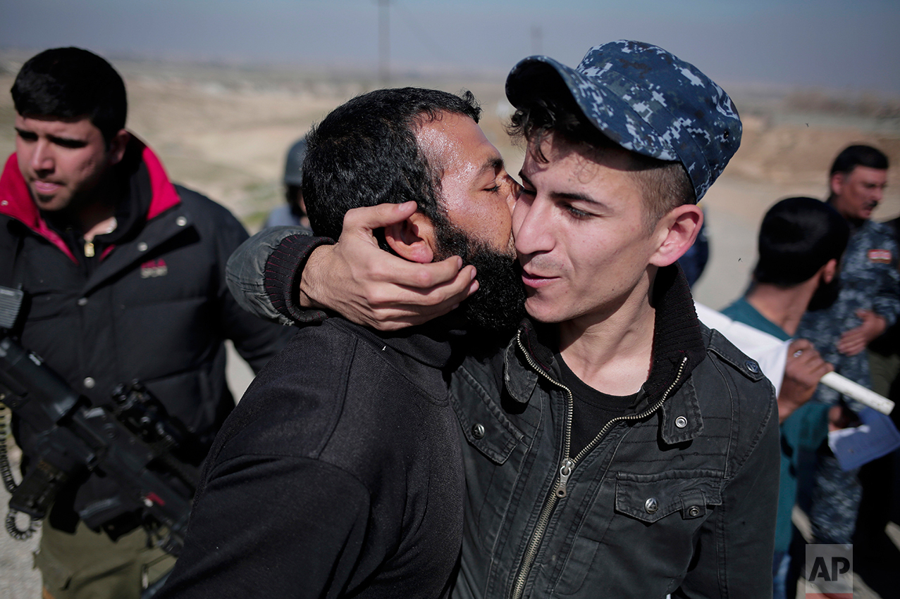  A civilian kisses a federal police officer after escaping Islamic State territory in the town of Abu Saif, Tuesday, Feb. 21, 2017. Iraqi forces advanced into the southern outskirts of Mosul in a push to drive Islamic State militants from the city's 