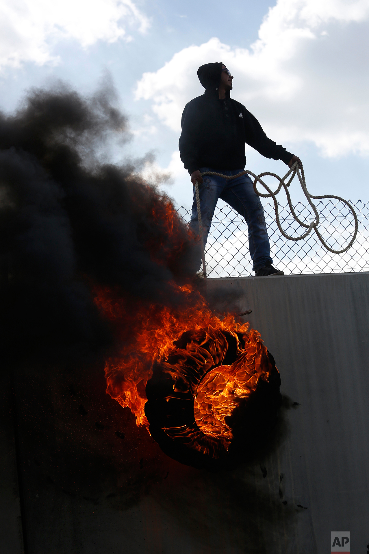  Palestinian protesters climb over the separation barrier with Israel during a demonstration marking the 12th anniversary of their campaign against Israel's separation barrier in the West Bank village of Bilin near Ramallah, Friday, Feb. 17, 2017. (A