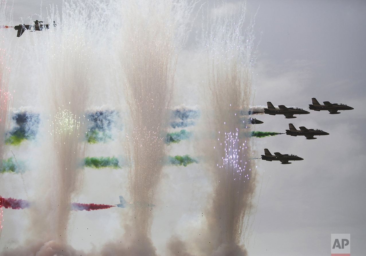  Military aircraft fly in formation as fireworks explode at the International Defense Exhibition and Conference, known by the acronym IDEX, in Abu Dhabi, United Arab Emirates, Sunday, Feb. 19, 2017. (AP Photo/Jon Gambrell) 