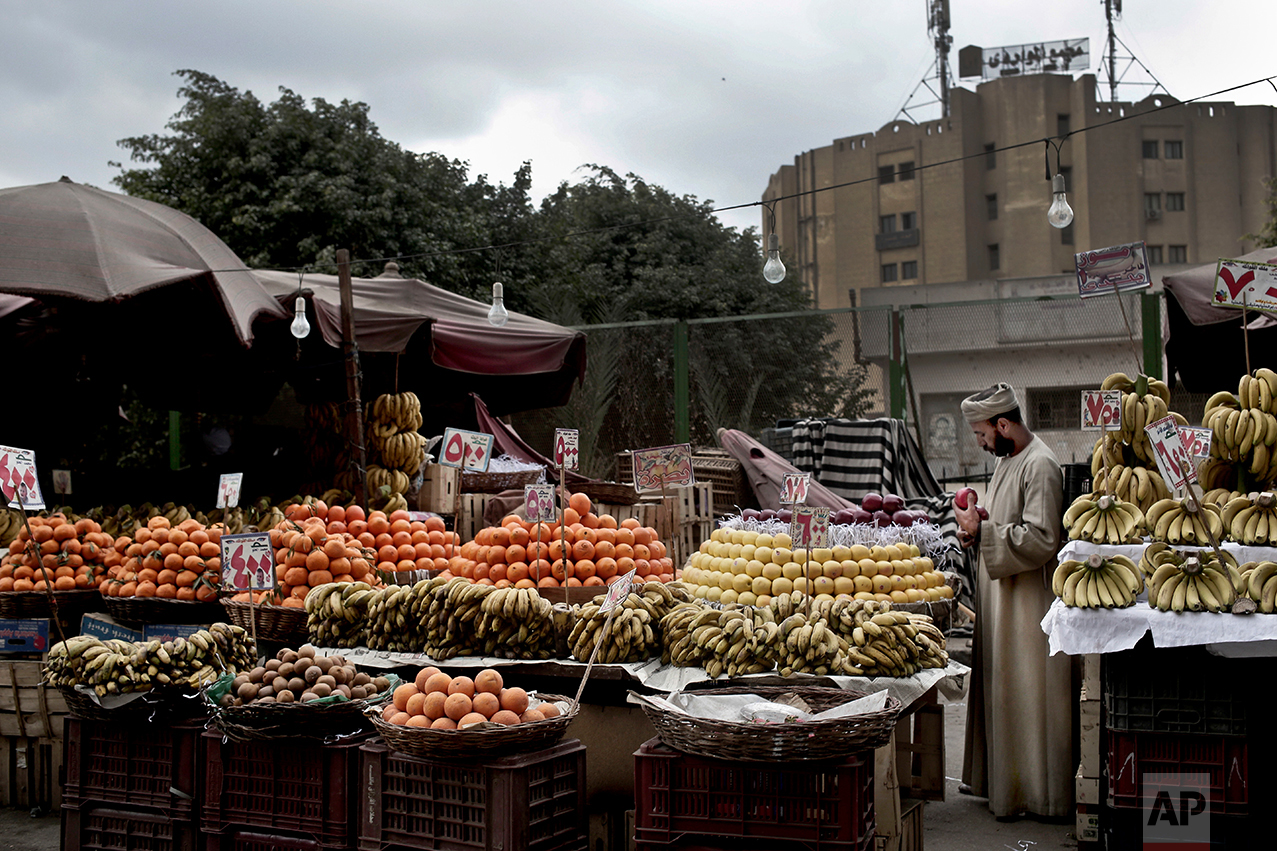  A fruit vendor checks an apple as he waits for customers in the Sayeda Zeinab neighborhood of Cairo, Egypt on Feb. 14, 2017. Egyptians are cutting spending and trying to make it through the country’s worst inflation in a decade under President Abdel