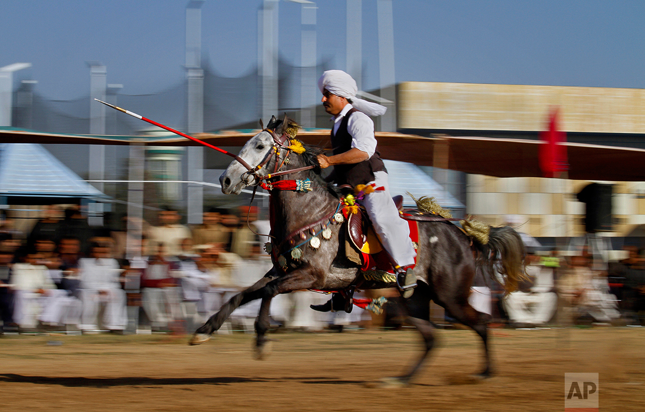  A Pakistani rider races to target a wooden peg during a tent pegging competition organized by the Pakistan Sports Board, in Islamabad, Pakistan, Sunday, Feb. 26, 2017. In tent pegging, a horseman gallops and uses a sword or a lance to pierce, pick u