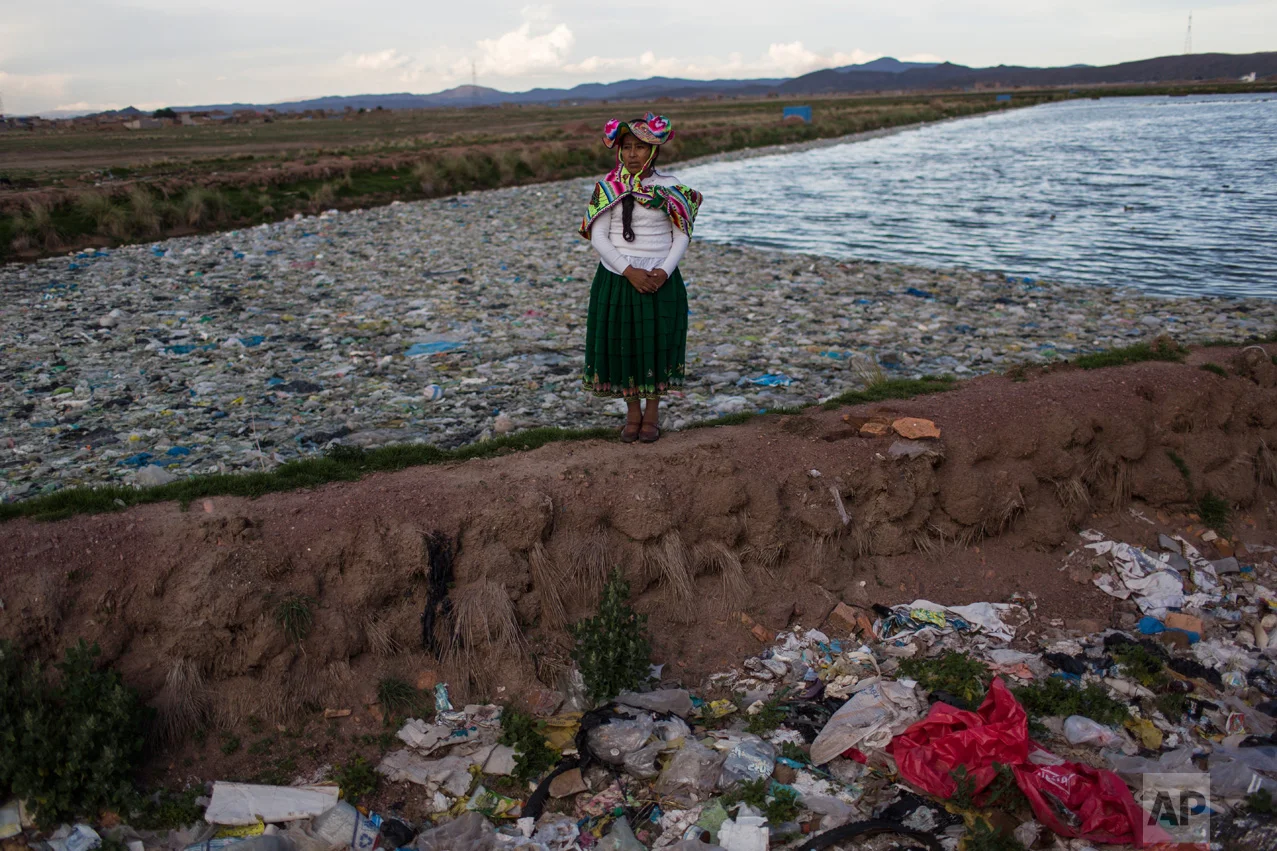 In this Feb. 1, 2017 photo, environmental activist Maruja Inquilla poses for a photo next to a Municipal waste treatment plant with water that flows into Lake Titicaca, in Juliaca, in the Puno region of Peru. "If the frogs could talk they would say, 'This is killing me,'" said Inquilla, who recently showed up at the Puno governor's house carrying plastic bags filled with hundreds of dead frogs in protest. (AP Photo/Rodrigo Abd)