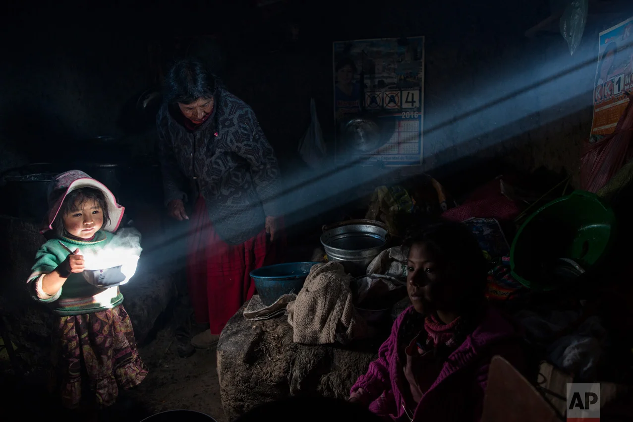 In this Feb. 4, 2017 photo, a child holds a bowl of hot food as the Avila family has lunch at their home in Coata, a small village on the shore of Lake Titicaca in the Puno region of Peru. Lake Titicaca was once worshipped by Incas who proclaimed its deep blue waters the birthplace of the sun, but today high levels of mercury, cadmium, zinc and copper are found in the fish locals consume, according to a 2014 government study. (AP Photo/Rodrigo Abd)
