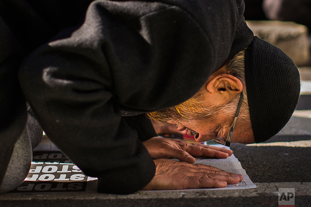  A man prays during a rally against President Donald Trump's executive order banning travel from seven Muslim-majority nations, in New York's Times Square, Sunday, Feb. 19, 2017. (AP Photo/Andres Kudacki) 