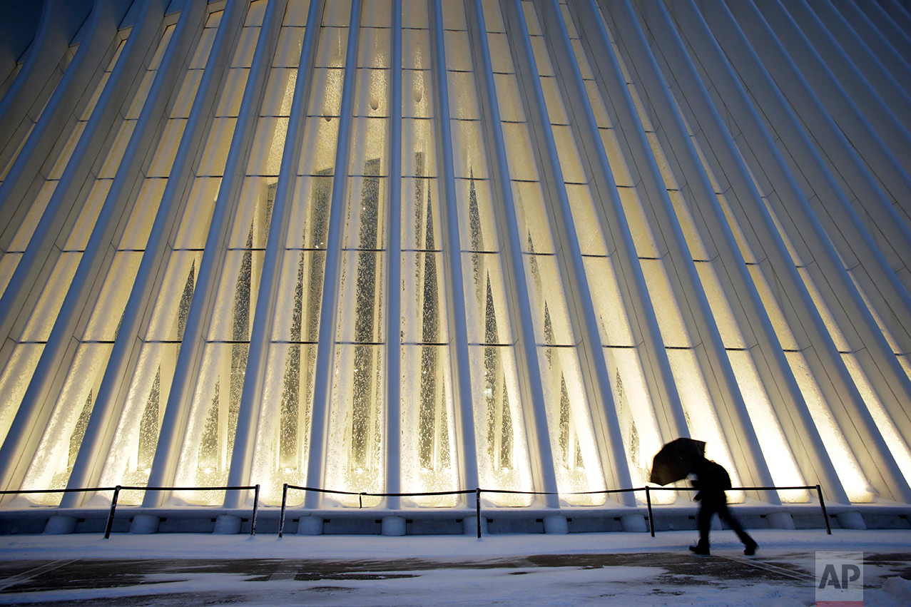  A man makes his way through wind and snow past the Oculus of the World Trade Center Transportation Hub, Thursday, Feb. 9, 2017, in New York. A powerful, fast-moving storm swept through the northeastern U.S. Thursday, making for a slippery morning co