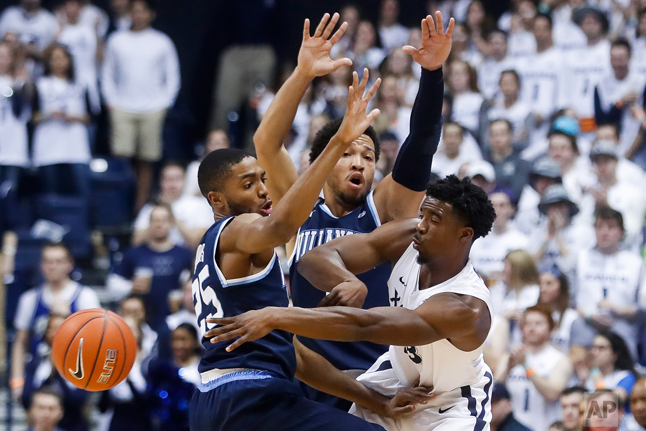  Xavier's Quentin Goodin, right, passes against Villanova's Mikal Bridges (25) and Jalen Brunson, center, in the first half of an NCAA college basketball game, Saturday, Feb. 11, 2017, in Cincinnati. (AP Photo/John Minchillo) 