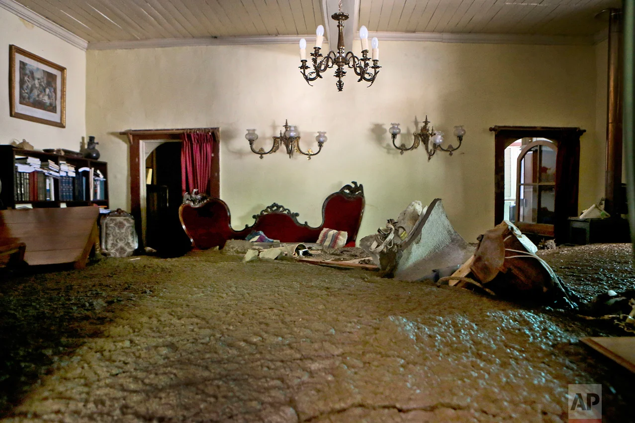 Sludge from the overflowing of the Estero San Jose River fills the living room of a home in San Alfonso, Santiago, Chile, Sunday, Feb. 26, 2017. Floods caused by Andean rainfall are causing havoc in parts of Chile, triggering landslides, cutting roads and isolating thousands of people. (AP Photo/Esteban Felix)