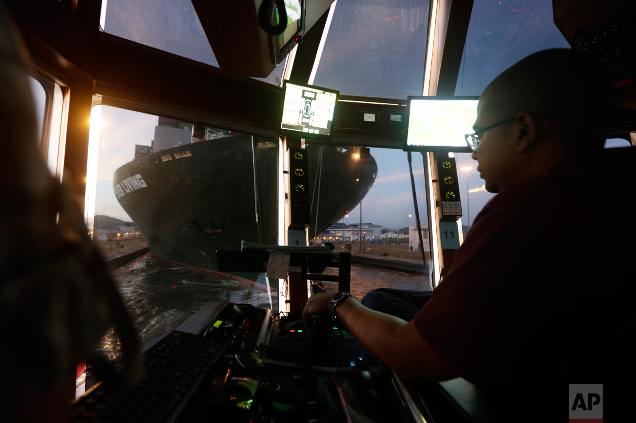 In this Jan. 18, 2017 photo, tugboat Captain Antonio Wray guides the Ever Living, a Neo-Panamax cargo ship, through the Cocoli locks that are part of the new Panama Canal expansion project in Cocoli, Panama. Before the canal opened in late June 2016, tugboat pilots expressed concern about what they said was insufficient training for new maneuvers that are now required. (AP Photo/Arnulfo Franco)