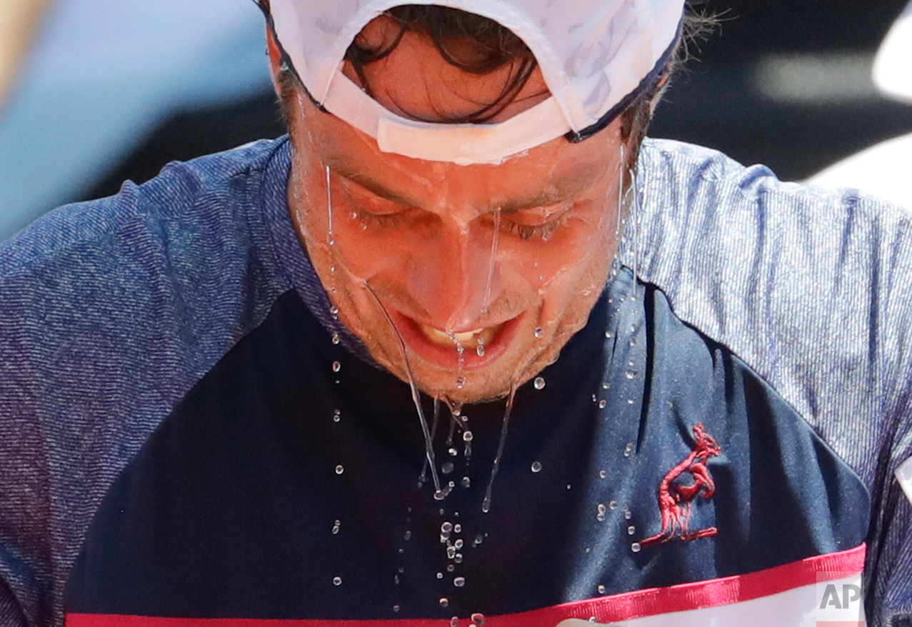 Italy's Paolo Lorenzi cools down with water during a Davis Cup first round tennis match against Argentina's Guido Pella in Buenos Aires, Argentina, Friday, Feb. 3, 2017. (AP Photo/Natacha Pisarenko)