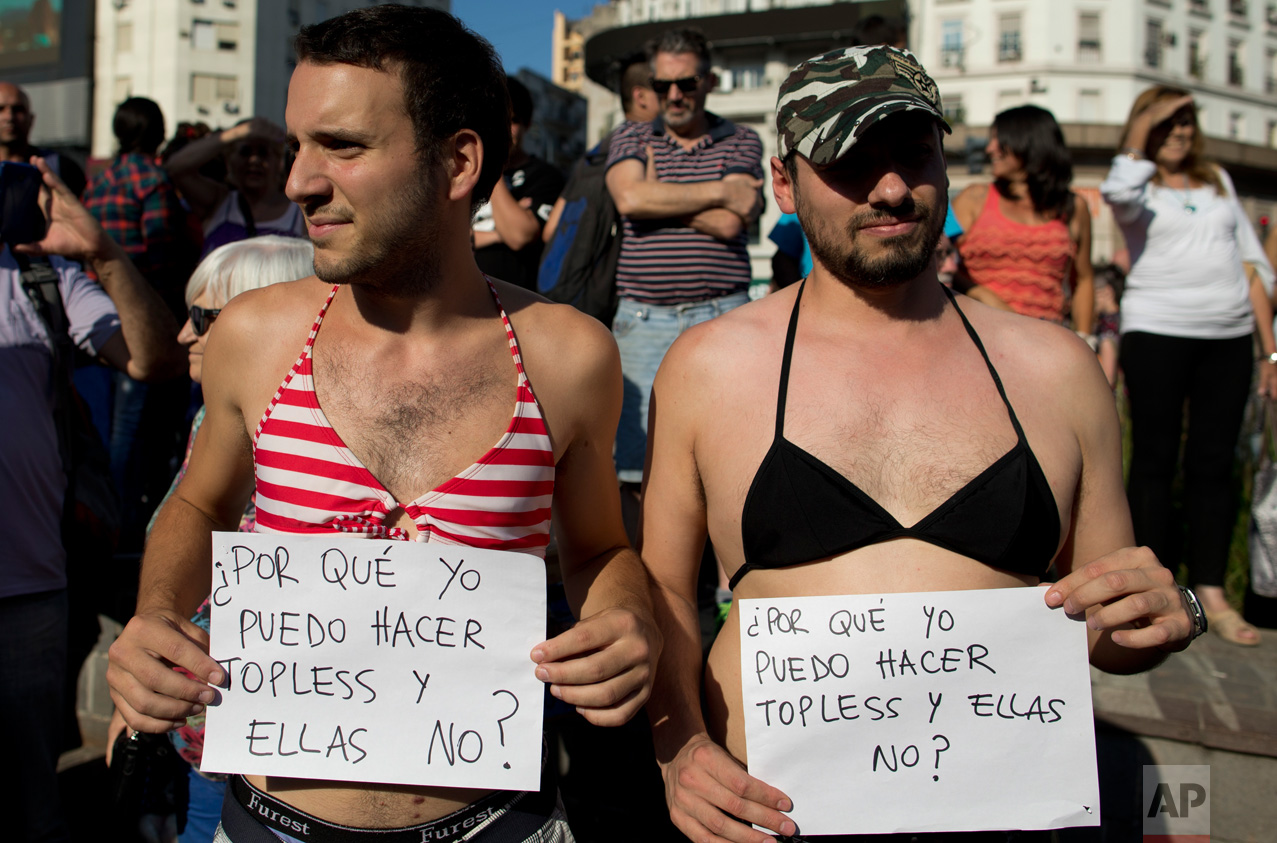  Men in bikini tops hold signs that read in Spanish "Why can I go topless and they can't" during a bare-breasted demonstration in Buenos Aires, Argentina, Tuesday, Feb. 7, 2017. People protested after police threatened several weeks ago to detain sev