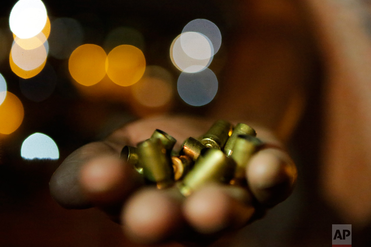  Erlita Pereira Goncalves shows police and photographers the casings of bullets she said were used to kill her son Nelson Eduardo in Vitoria, Espirito Santo state, Brazil, Thursday, Feb 9, 2017. Goncalves said her 30-year-old son was shot dead by att