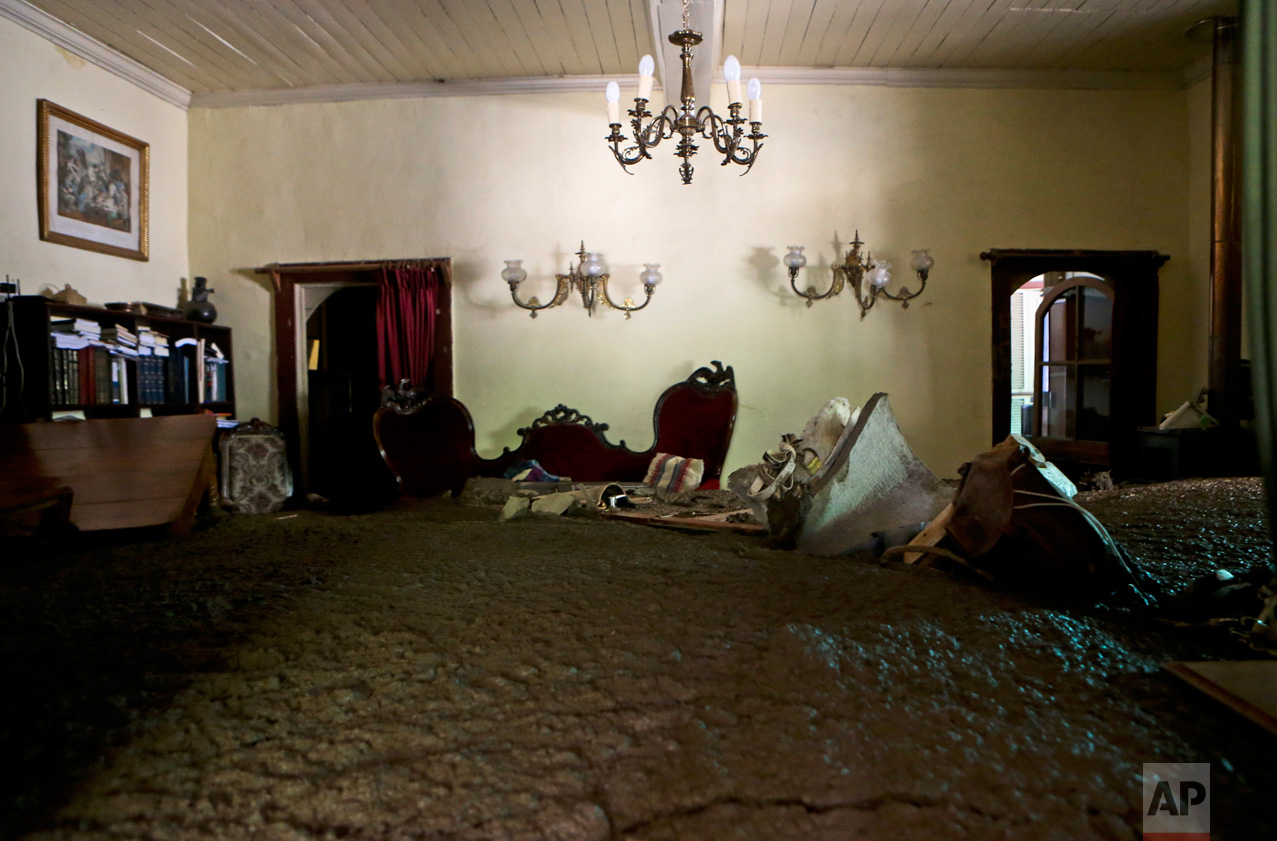 Sludge fills the living room of a home, brought by the overflowing of the Estero San Jose River in San Alfonso, Santiago, Chile, Sunday, Feb. 26, 2017. Floods caused by Andean rainfall are causing havoc in parts of Chile, triggering landslides, cutting roads and isolating thousands of people. (AP Photo/Esteban Felix)