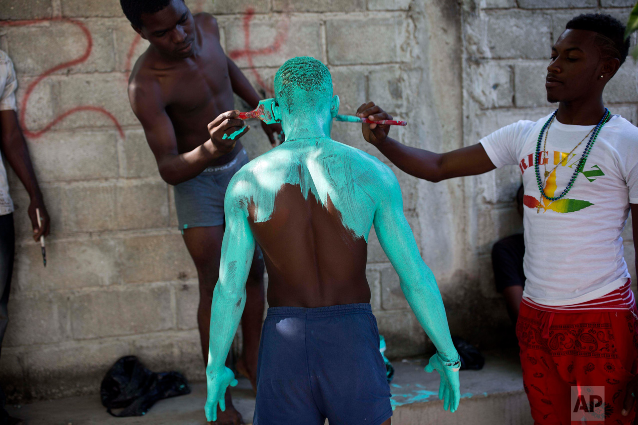 A Carnival performer is painted by his friends before the start of a parade in Les Cayes, Haiti, Tuesday, Feb. 28, 2017. Tuesday's celebrations were the last major party day of Haiti's Carnival, a mixture of Catholic pre-Lenten festivities and African, Spanish and native cultures found throughout the Americas and the Caribbean. (AP Photo/Dieu Nalio Chery)