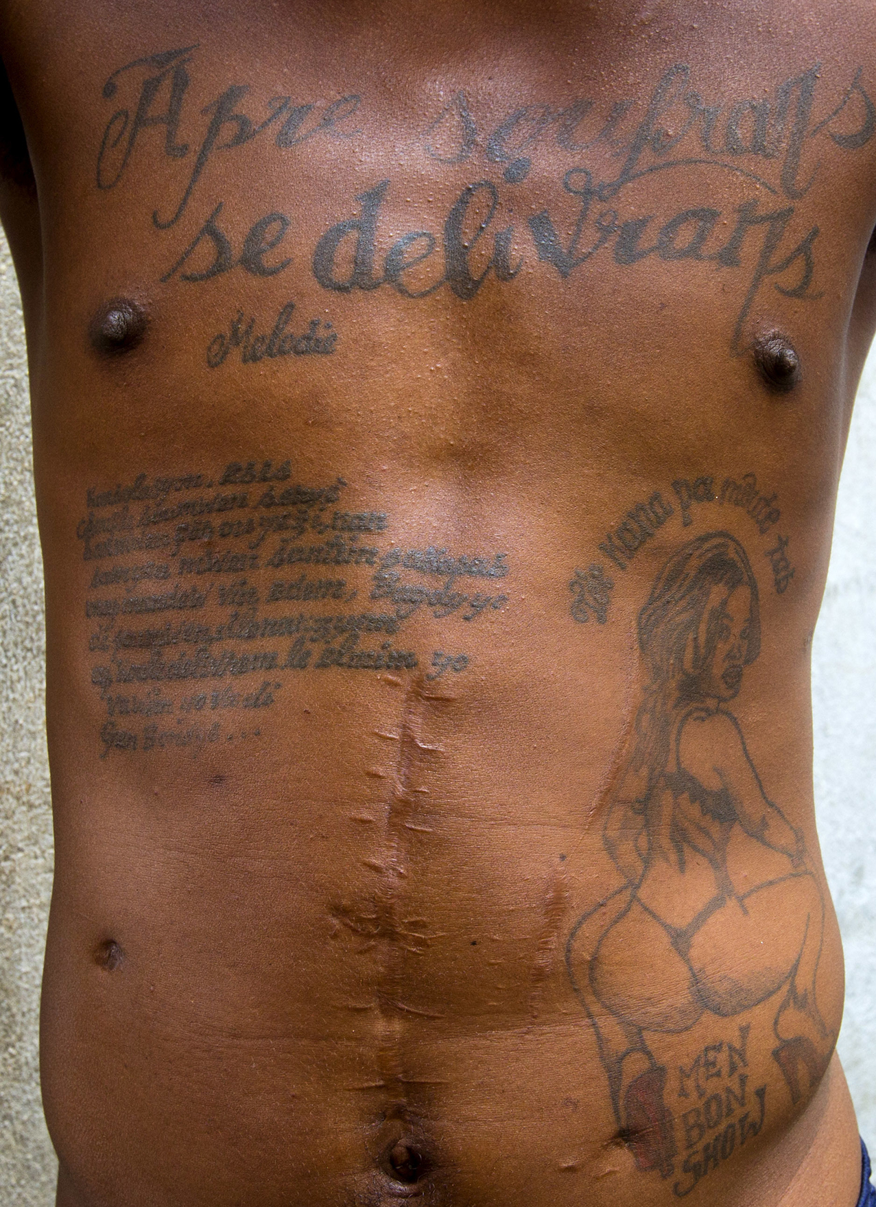  This Feb. 13, 2017 photo shows the tattoos on the chest and abdomen of a prisoner incarcerated at the National Penitentiary in downtown Port-au-Prince, Haiti. The tattoo on his chest reads in Haitian Creole: "After suffering is deliverance." ( AP Ph