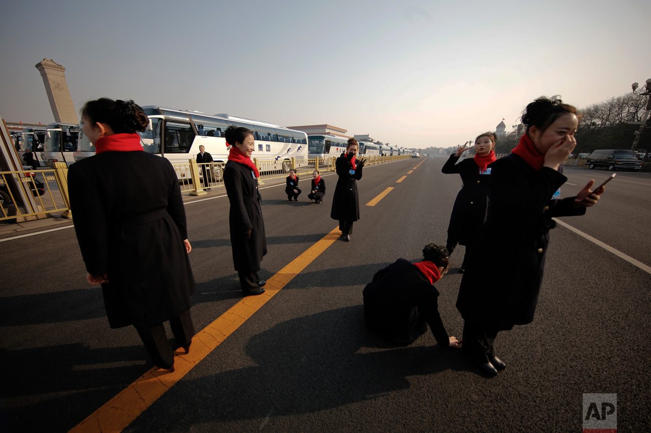 In this Friday, March 3, 2017 photo, hospitality staff enjoy the moment as they take pictures adjacent to the Great Hall of the People during the Chinese People's Political Consultative Conference (CPPCC) in Beijing. (AP Photo/Andy Wong)