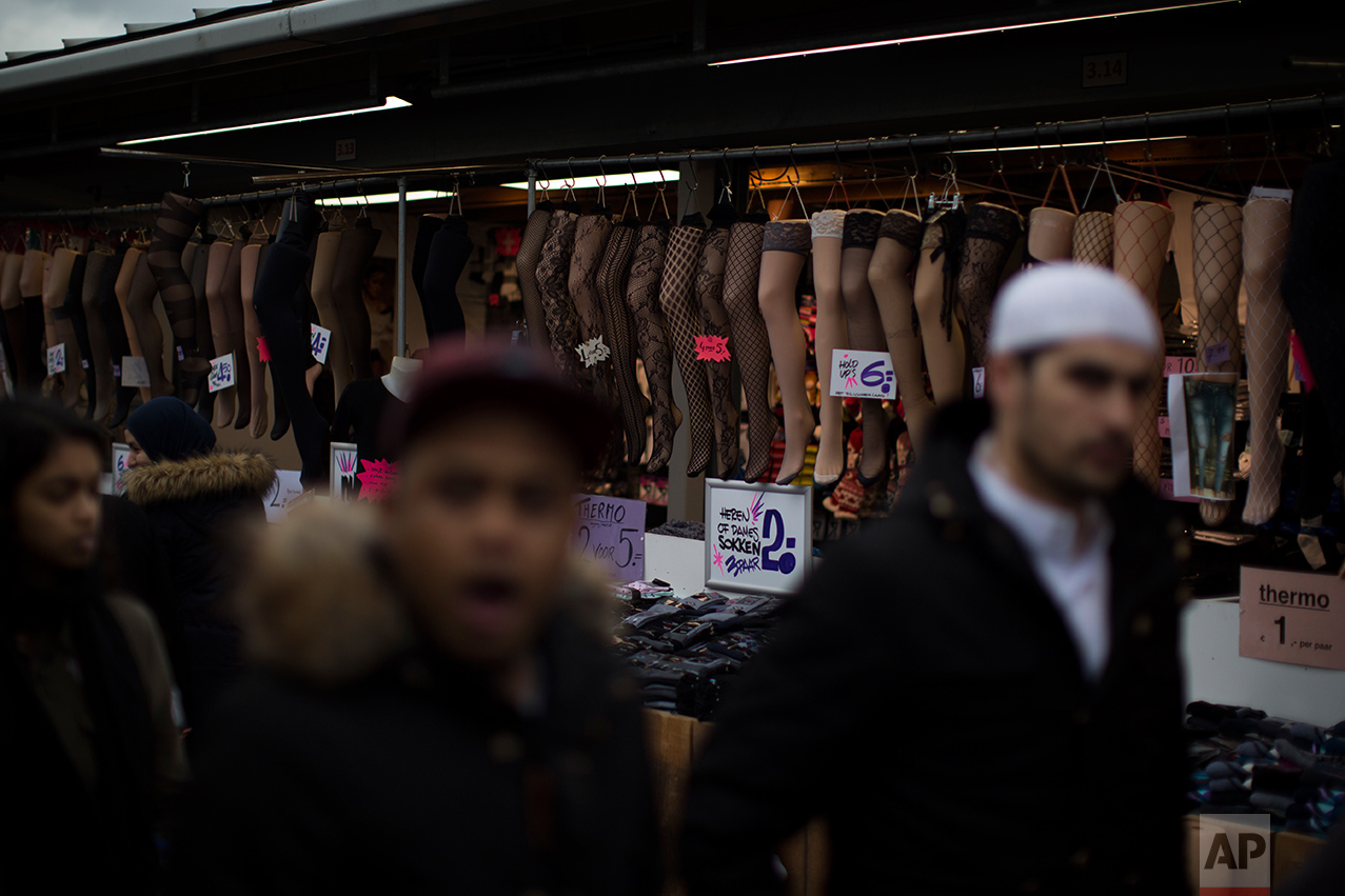 In this Saturday, March 4, 2017 photo, people walk past socks and stockings that are displayed for sale at a market stall in The Hague, The Netherlands. (AP Photo/Emilio Morenatti)
