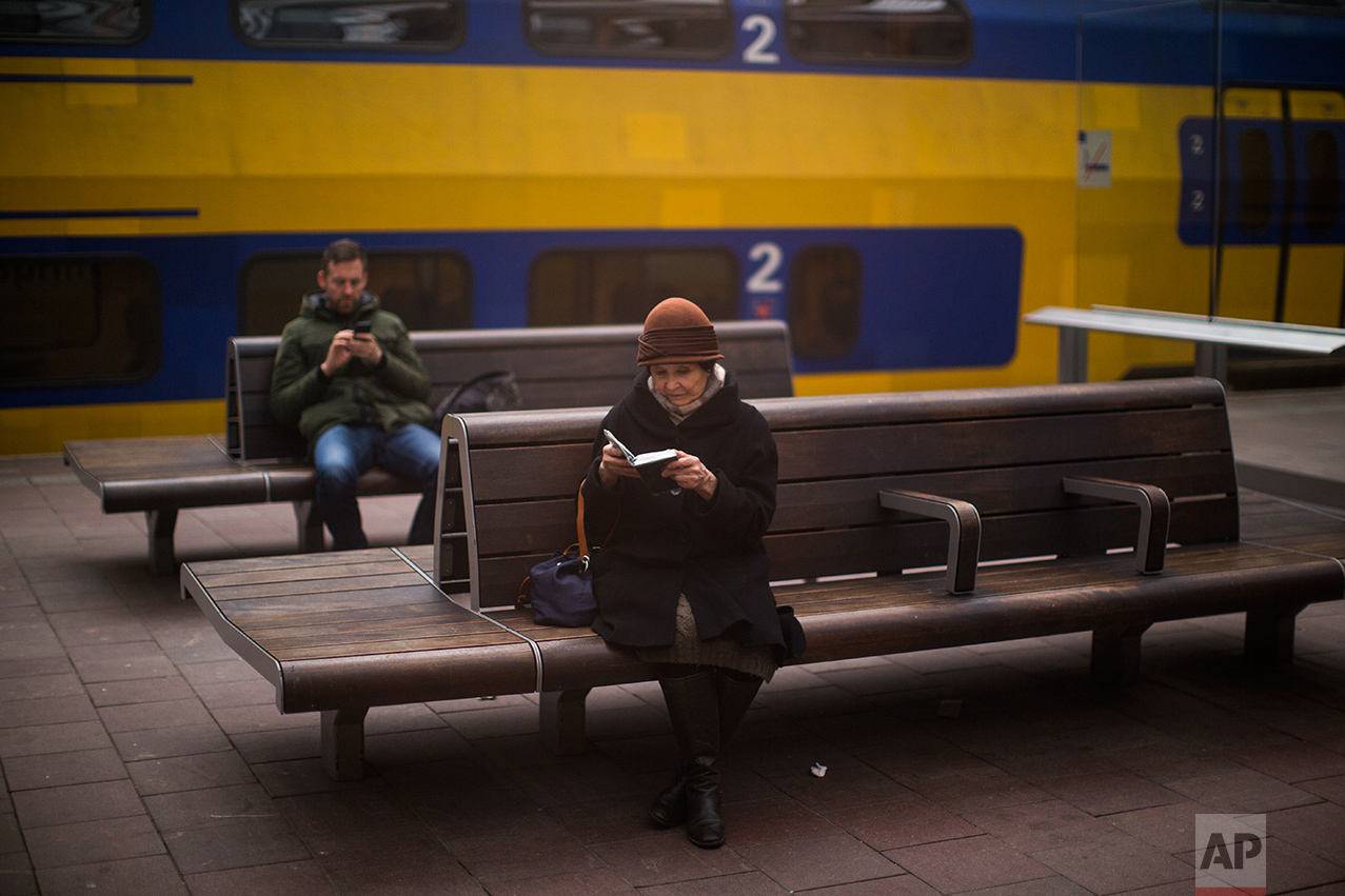 In this Thursday, March 2, 2017 photo, a woman reads the bible at the central station in The Hague, Netherlands. (AP Photo/Emilio Morenatti)