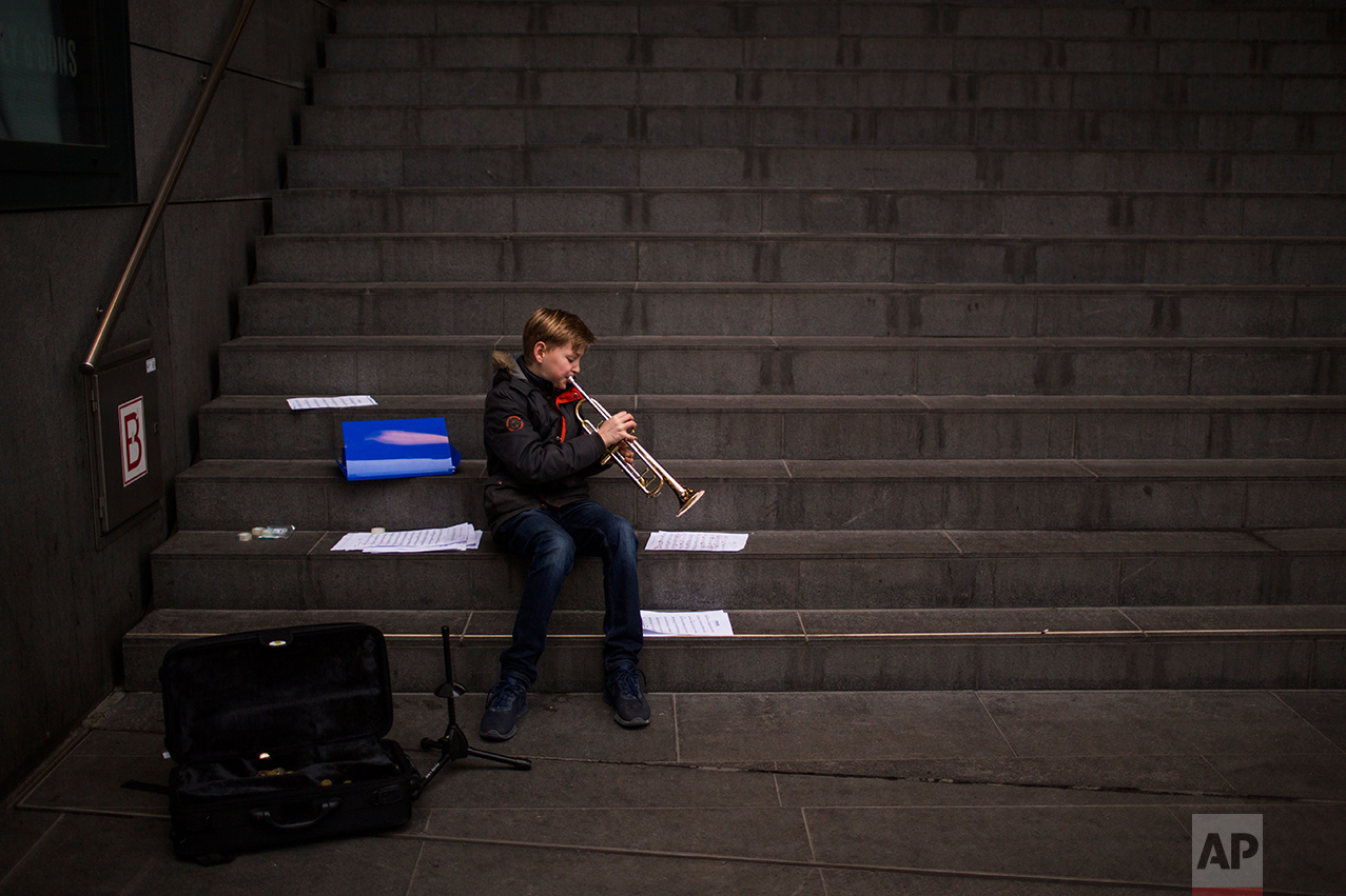 In this Friday, March 3, 2017 photo, Agne, 12, plays his trumpet as he practices in the centre of The Hague, The Netherlands. Of the Netherlands' 17 million people, just over one in five now have a migrant background _ rising to roughly half-and-half in the Netherlands' four largest melting-pot cities: Amsterdam, Rotterdam, Utrecht and The Hague. (AP Photo/Emilio Morenatti)