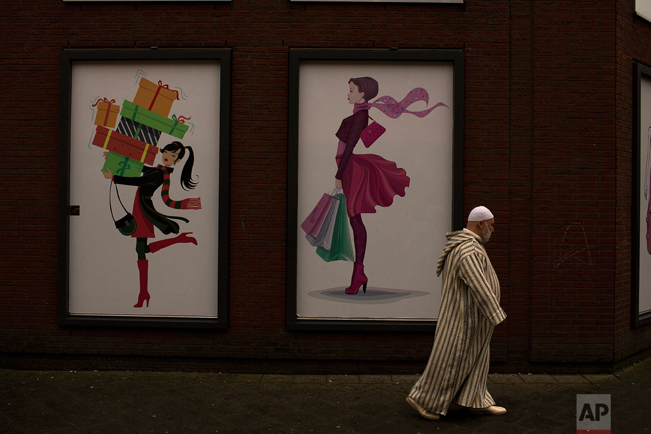 In this Friday, March 3, 2017 photo, a man walks past a clothes shop in the The Hague, The Netherlands. Islam is relatively new in the Netherlands and its spread has come as increasing numbers of native Dutch have abandoned religion. Those attending religious services at least once per month have dropped from about one in four in 1999 to about one in six now. (AP Photo/Emilio Morenatti)