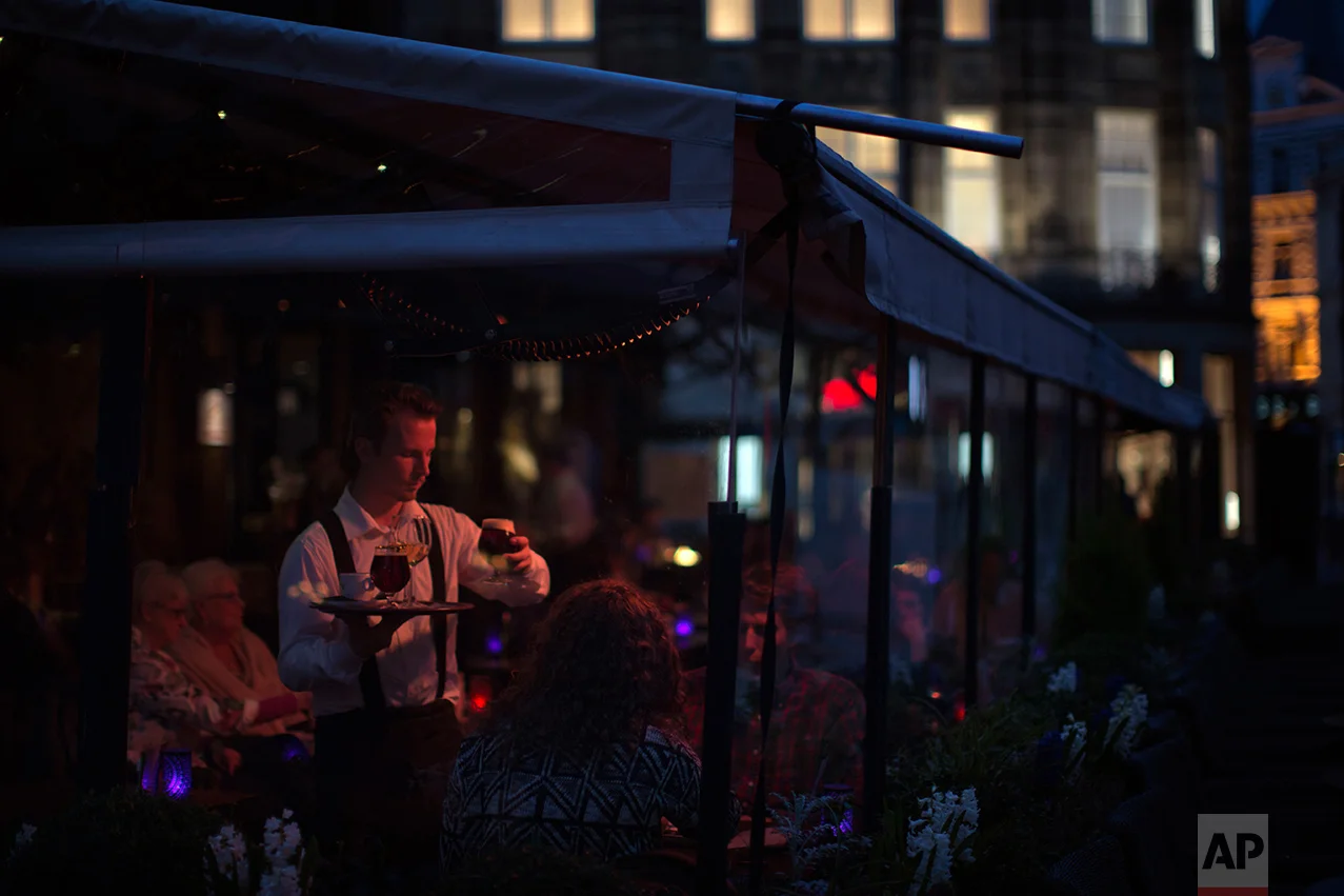 In this Saturday, March 4, 2017 photo, people have dinner at a restaurant at The Hague, The Netherlands. The Netherlands is densely populated, with some of its land reclaimed from the sea. Geert Wilders supporters cite lack of space as another reason for the Netherlands to close its doors. The country is full, they argue. (AP Photo/Emilio Morenatti)