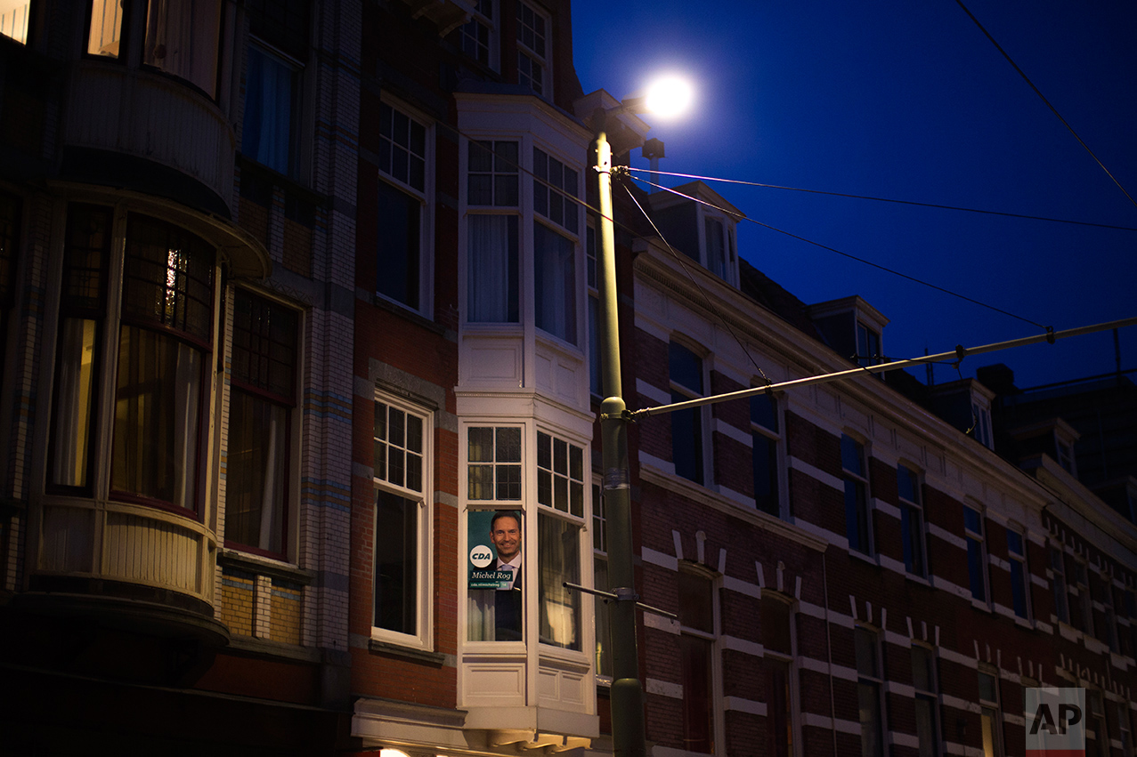 In this Friday, March 3, 2017 photo, a poster with a portrait of Michel Rog, candidate for the CDA (Christian democratic party), is displayed in a window in the centre of The Hague, The Netherlands. Ahead of a Dutch vote that will indicate whether populism in Europe is gathering strength or blowing over, divisive questions about immigration and Islam are testing the Netherlands' famed capacity for tolerance. (AP Photo/Emilio Morenatti)