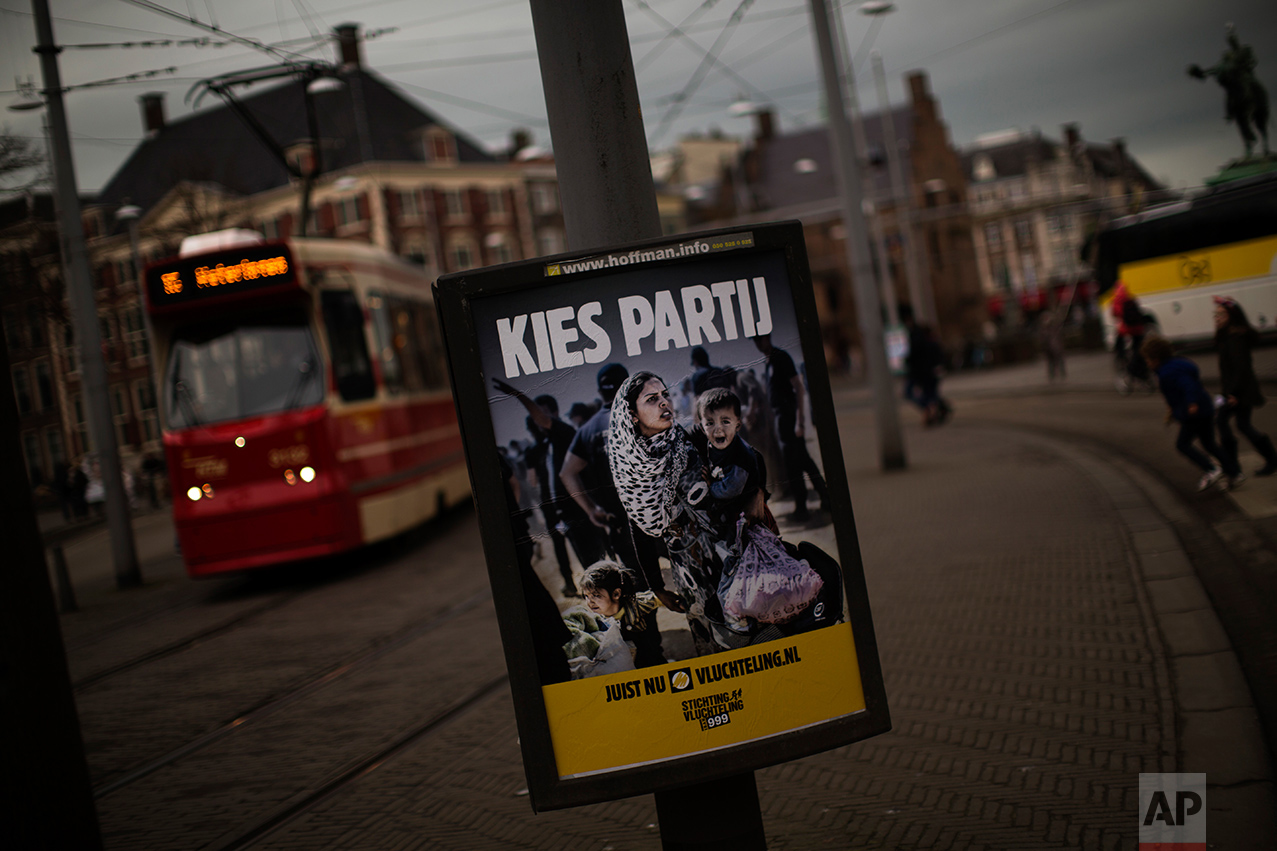 In this Friday, March 3, 2017 photo, a banner by Stichting Vluchteling (Refugee Foundation of Netherlands), that reads in Dutch "Choose a Party" hangs on a lamppost in The Hague, The Netherlands. Ahead of a Dutch vote that will indicate whether populism in Europe is gathering strength or blowing over, divisive questions about immigration and Islam are testing the Netherlands' famed capacity for tolerance and inclusiveness. (AP Photo/Emilio Morenatti)
