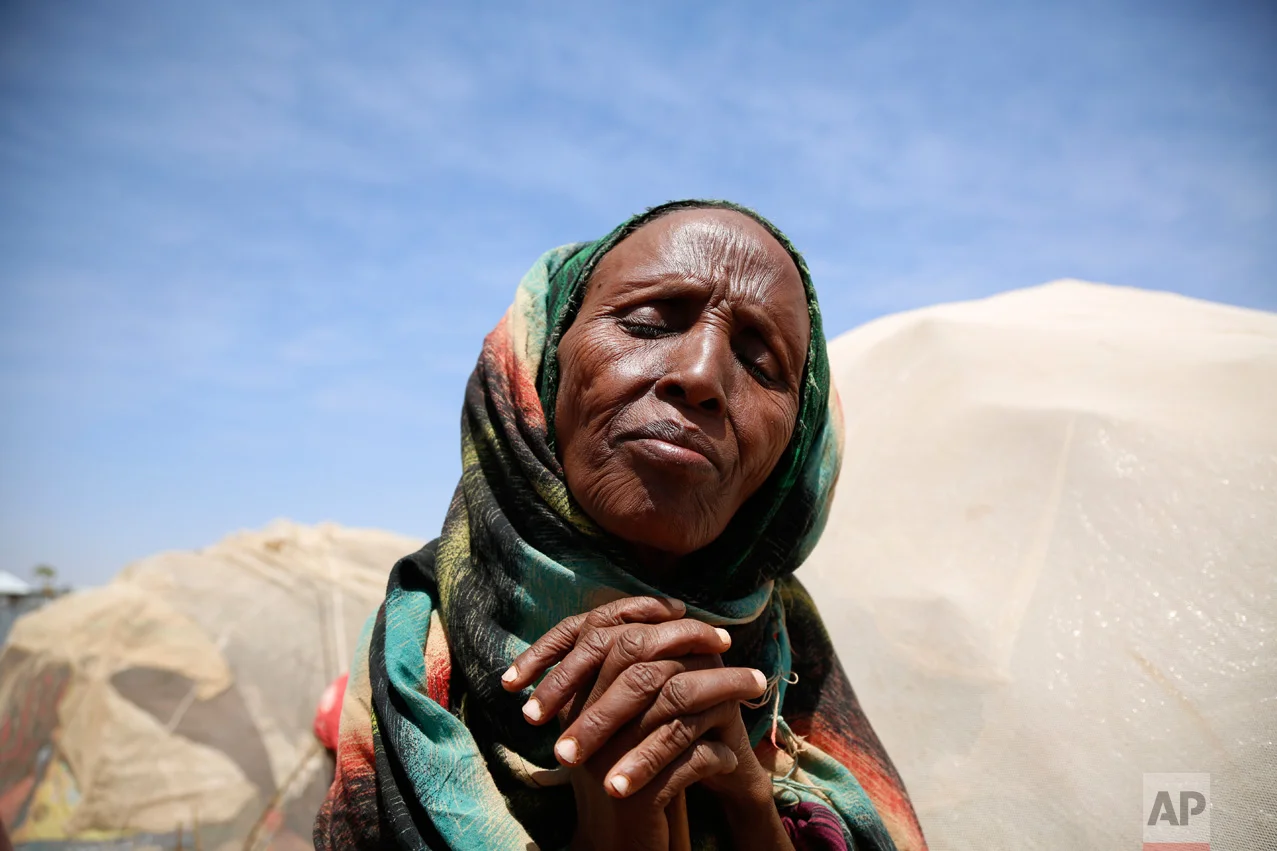 A woman clasps her hands together at the internally displaced persons camp in Baidoa, Somalia, Tuesday, March 7, 2017, where the drought is severe. Visibly shocked by the suffering of malnourished Somalis and cholera victims during an emergency visit, U.N. Secretary-General Antonio Guterres on Tuesday urged international support to alleviate Somalia's worsening hunger crisis. (AP Photo/Khaled Kazziha)