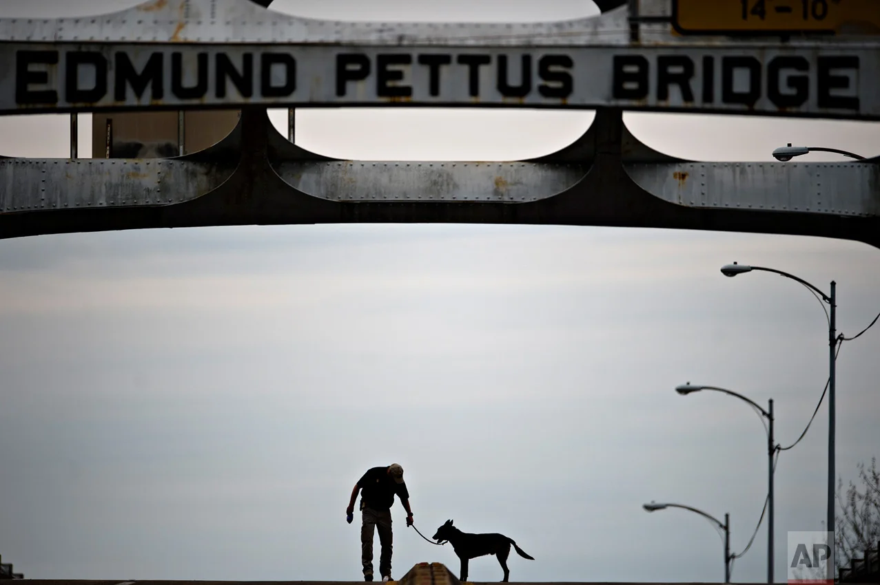 An Alabama State Trooper and a K9 dog check the Edmund Pettus Bridge for explosives before the annual re-enactment of a key event in the civil rights movement in Selma, Ala., Sunday, March 5, 2017. Sunday marked the 52nd anniversary of the march across the Edmund Pettus Bridge over the Alabama River in Selma. On March 7, 1965, African-Americans seeking voting rights launched a march across the bridge en route to Montgomery but were attacked by police. The violent episode became known as "Bloody Sunday." (Albert Cesare/The Montgomery Advertiser via AP)