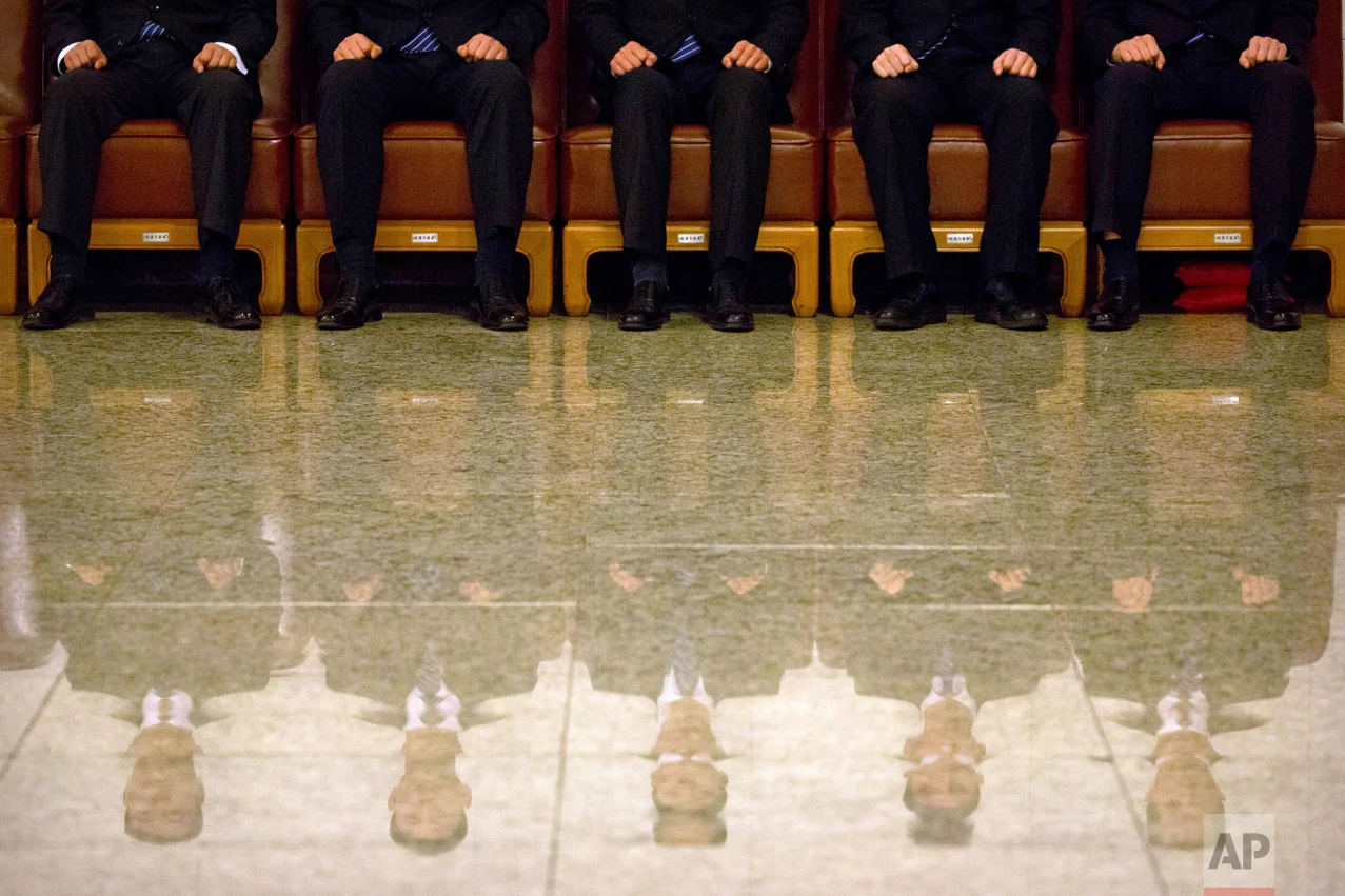 Security personnel are reflected in the floor as they sit on guard during a plenary session of China's National People's Congress at the Great Hall of the People in Beijing, Wednesday, March 8, 2017. China's top leadership as well as thousands of delegates from around the country are gathered at the Chinese capital for the annual legislature meetings. (AP Photo/Mark Schiefelbein)