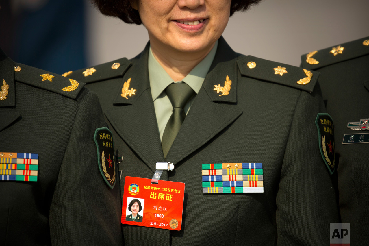 In this Friday, March 3, 2017 photo, a military delegate poses for a group photo as she arrives for of the opening session of the Chinese People's Political Consultative Congress (CPPCC) at the Great Hall of the People in Beijing. (AP Photo/Mark Schiefelbein)