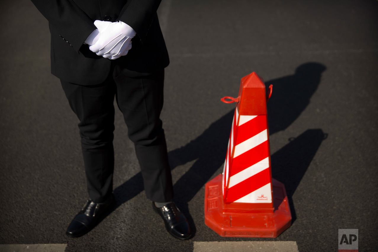 In this Wednesday, March 8, 2017 photo, a security official stands next to a traffic cone as he guards a crosswalk outside of the Great Hall of the People before a plenary session of China's National People's Congress (NPC) in Beijing. (AP Photo/Mark Schiefelbein)