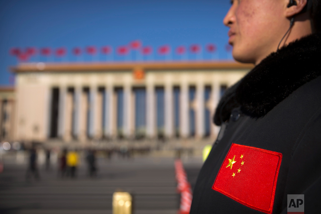 In this Sunday, March 12, 2017 photo, a security official with a Chinese flag patch on his jacket stands guard outside of the Great Hall of the People before a plenary session of the National People's Congress (NPC) in Beijing. (AP Photo/Mark Schiefelbein)