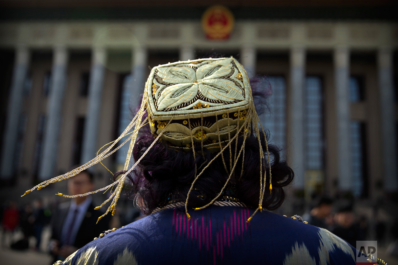 In this Saturday, March 11, 2017 photo, tassels on the hat of an ethnic minority delegate blow in the breeze as she arrives for a plenary session of the Chinese People's Political Consultative Congress (CPPCC) at the Great Hall of the People in Beijing. (AP Photo/Mark Schiefelbein)