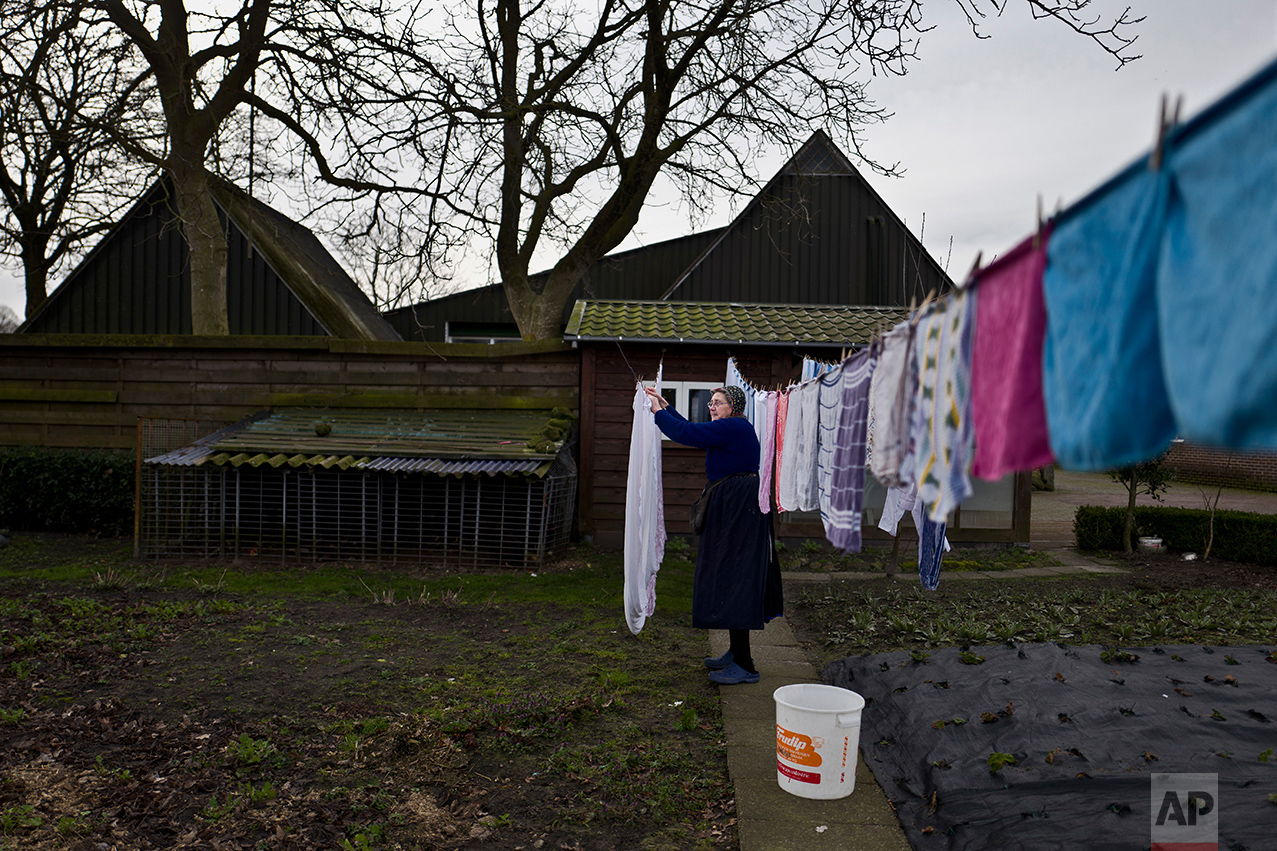  An elderly Dutch woman hangs her laundry in front of her home in Staphorst, Netherlands, Wednesday, March 15, 2017. (AP Photo/Muhammed Muheisen) 