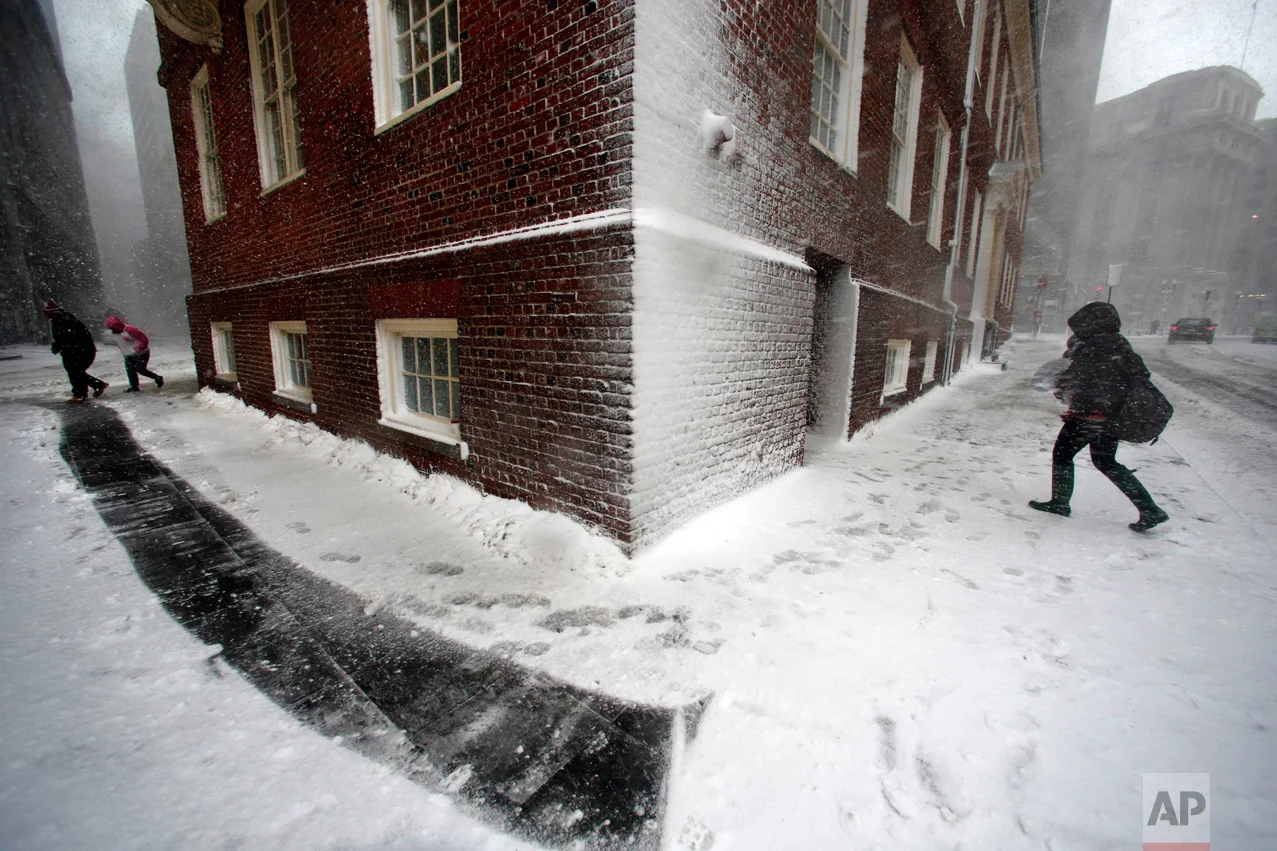 People walk in the wind-driven snow during a winter storm in Boston on Tuesday, March 14, 2017. The powerful nor'easter that paralyzed much of the Washington-to-Boston corridor Tuesday fell short of the predicted snowfall in many areas. (AP Photo/Michael Dwyer)