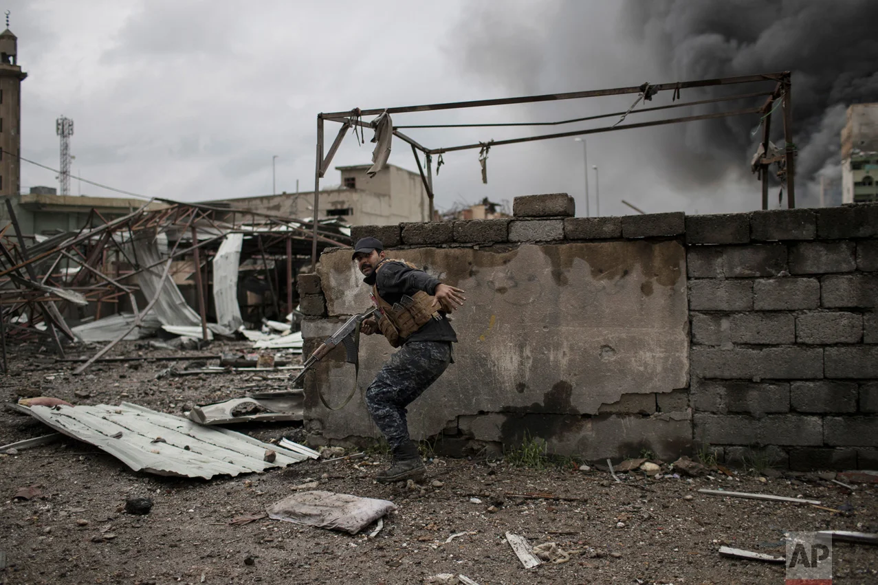 A Federal Police soldier runs for cover during fighting against Islamic State militants in western Mosul, Iraq, Thursday, March 16, 2017. U.S.-backed Iraqi forces have been battling the IS group for nearly a month as they try to retake the remainder of the city. (AP Photo/Felipe Dana)