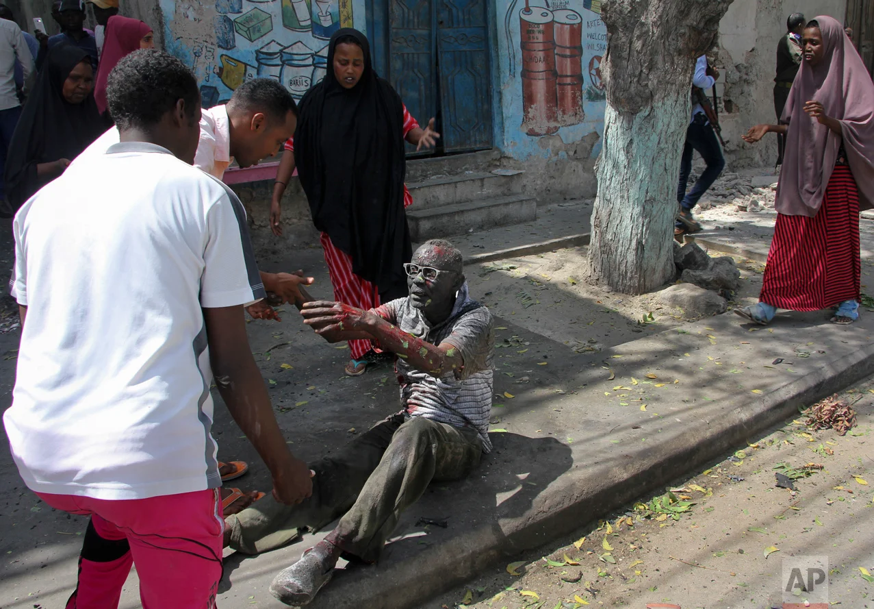 A wounded man reaches out to rescuers after a car bomb attack in Mogadishu, Somalia, on Monday, March 13, 2017. A suicide car bomber detonated explosives near the Weheliye hotel in the capital Monday morning, killing several on the busy Maka Almukarramah road, according to police. (AP Photo/Farah Abdi Warsameh)