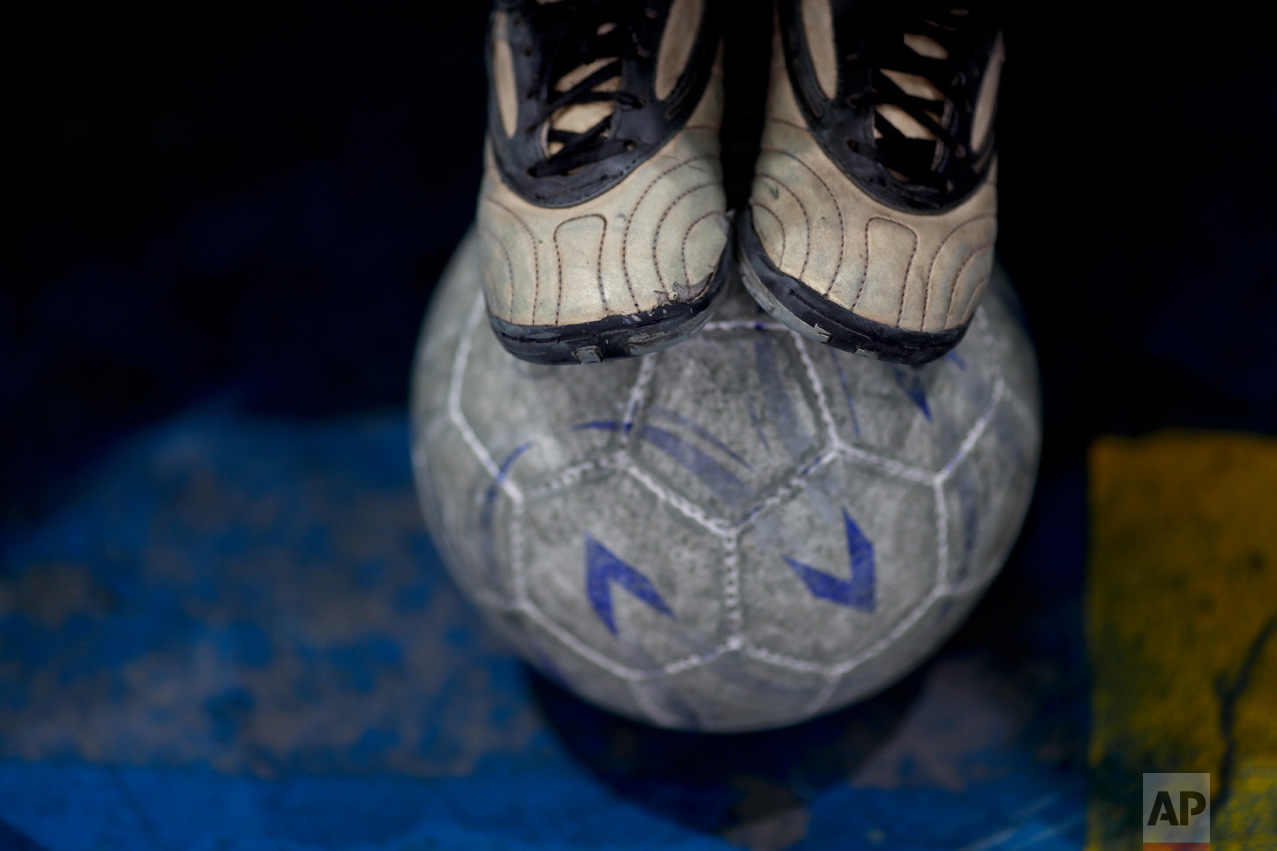 In this Nov. 11, 2016 photo, a young player steps on a soccer ball during a training session at the youth soccer academy Club Social Parque in a working class neighborhood of Buenos Aires, Argentina. Club Social Parque was founded in 1949 where today about 150 children from all economic levels train together twice a week and compete on the weekends on small indoor courts. (AP Photo/Natacha Pisarenko)